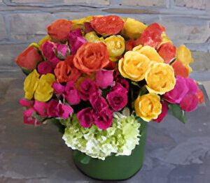 Colorful bouquet of roses in green vase.