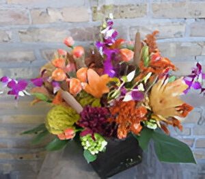Colorful floral arrangement against a brick wall.