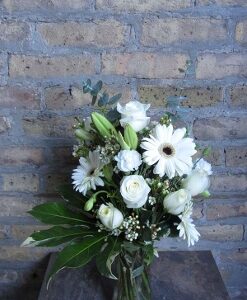 White flower bouquet against a brick wall.