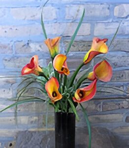Vibrant calla lilies in a black vase.