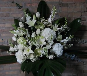 White floral arrangement against a brick wall.