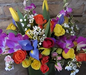 Colorful flower bouquet against brick wall.