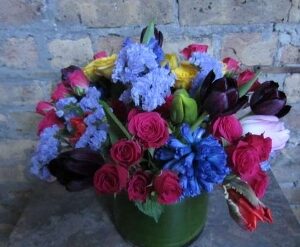 Colorful flower bouquet against a brick wall.